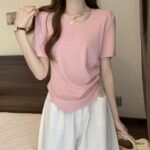 Camiseta lisa y sencilla, con diseño abierto y un mini dije